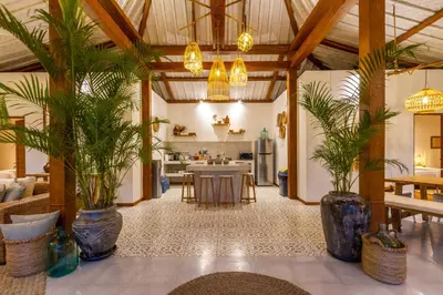 a living room with potted plants and a kitchen at Villa Loma by Alfred in Bali in Seminyak