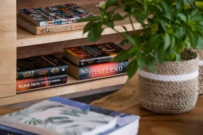 a stack of books on a shelf with a potted plant at Villa Mia by Villa Finder in Canggu