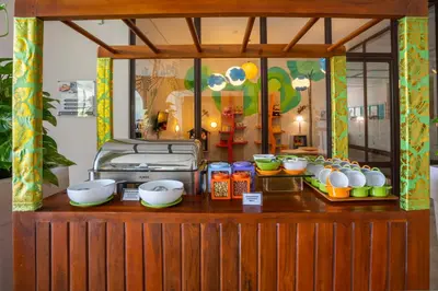 a counter with bowls and other food on it at Grand Livio Kuta Hotel in Legian