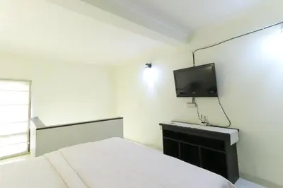 a bedroom with a bed and a tv on the wall at Permisol Homestay 88 in Denpasar
