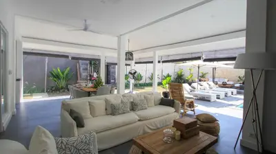 a living room with a couch and a table at Mahasari Villa in Seminyak