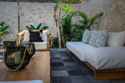 a living room with two chairs and a couch at Mahasari Villa in Seminyak