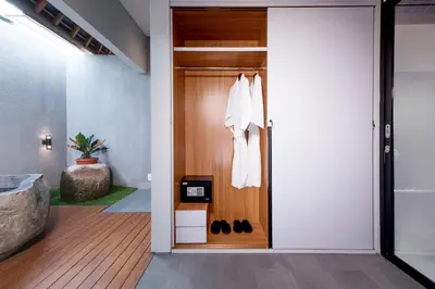 a pivot door in a hallway with a pair of shoes at Villa DeDayuh Seminyak in Seminyak