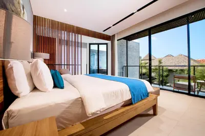 a bedroom with a bed and large glass windows at Villa DeDayuh Seminyak in Seminyak