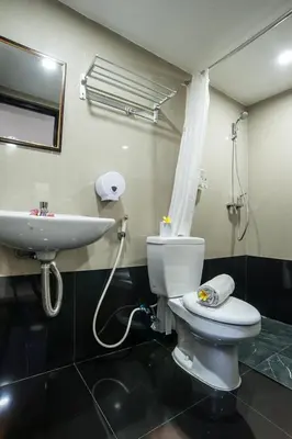 a bathroom with a white toilet and a sink at KELAN-TEL BALI in Jimbaran