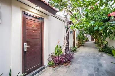 a door to a house with plants and a walkway at KELAN-TEL BALI in Jimbaran