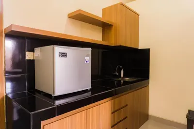 a kitchen with a sink and a small refrigerator at Cakra House in Denpasar