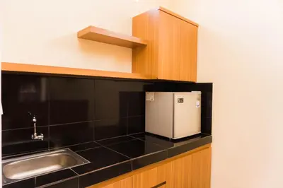 a small kitchen with a sink and black counter top at Cakra House in Denpasar
