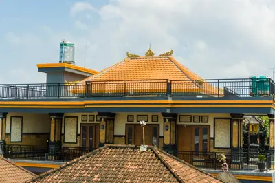 a building with an orange roof and a balcony at Cakra House in Denpasar