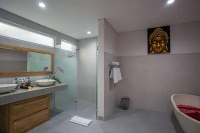 a bathroom with a tub and a sink and a mirror at The Awandari Villas Seminyak in Seminyak