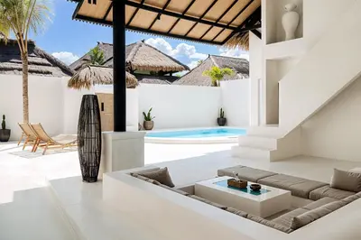 an outdoor living room with a couch and a table at Villa de Malicott in Seminyak