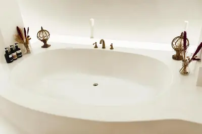 a white bathroom sink with candles on a counter at Villa de Malicott in Seminyak