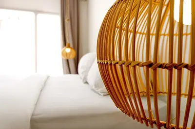a wicker chair sitting on a bed in a bedroom at Villa de Malicott in Seminyak