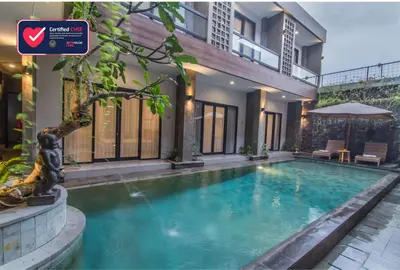 a swimming pool in front of a house at D Home Seminyak in Seminyak