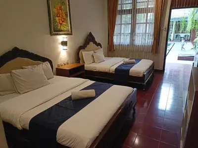 a hotel room with two beds and a window at Catur Adi Putra in Denpasar