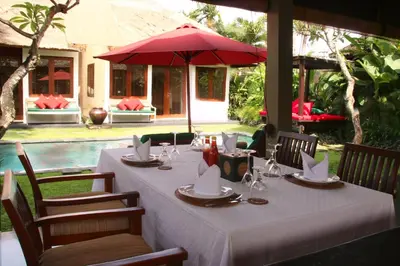 a table with a white table cloth and a red umbrella at Imani Villas in Canggu