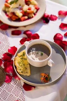 a plate with a cup of soup and a plate of food at Seminyak Sanctuary Villa by Ini Vie Hospitality in Seminyak