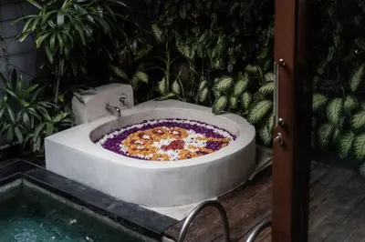 a large pizza in a bath tub in a garden at Seminyak Sanctuary Villa by Ini Vie Hospitality in Seminyak