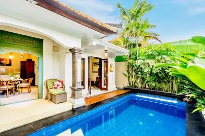 a villa with a swimming pool and a patio at Villa Retro 88 in Seminyak