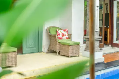 a porch with wicker chairs and a red pillow at Villa Retro 88 in Seminyak