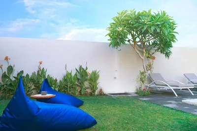 a garden with blue pillows on the grass at Villa Brabhan Seminyak in Seminyak