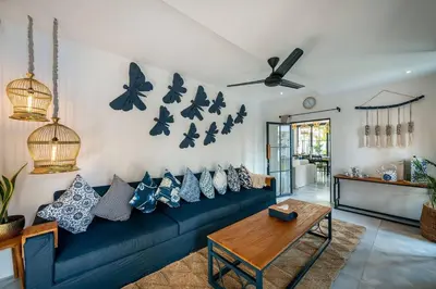 a living room with a blue couch and butterflies on the wall at Luxe 5 Bed, Sleeps 10, Butler, Walk to ShopsCafe in Seminyak