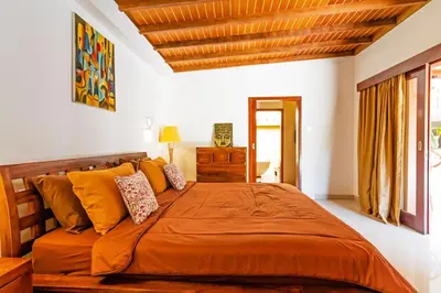 a bedroom with a large bed with orange sheets at Awesome 1BR Villa in the heart of Seminyak in Seminyak
