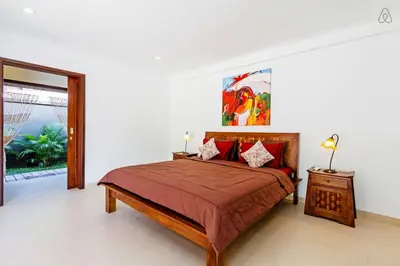 a bedroom with a large bed with red pillows at Awesome 1BR Villa in the heart of Seminyak in Seminyak