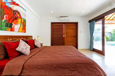 a bedroom with a large bed with red pillows at Awesome 1BR Villa in the heart of Seminyak in Seminyak