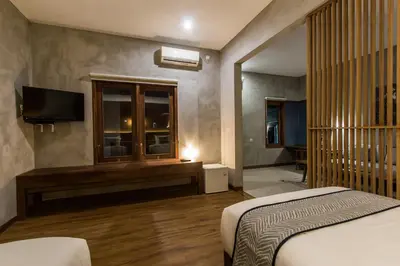 a bedroom with a bed and a tv and a window at Kuta Legian Villa 3 Bedroom Private pool in Legian