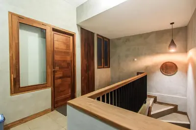a hallway with a wooden door and a staircase at Kuta Legian Villa 3 Bedroom Private pool in Legian