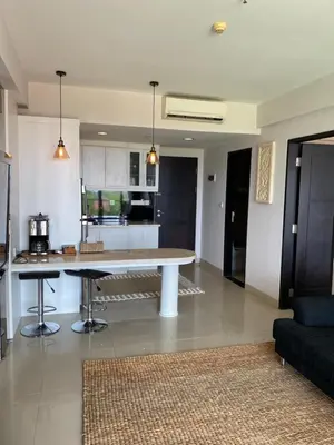 a kitchen and living room with a large table in it at Stylish 2 Bedroom Penthouse Apt, Newly Refreshed, 50 Mbps, Pool, Gym, Resto in Kuta