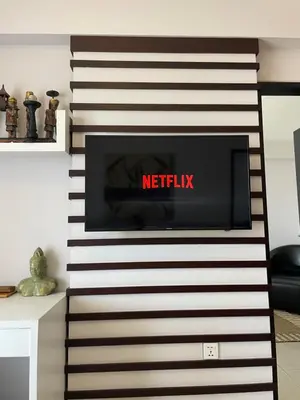 a television on a wall in a living room at Stylish 2 Bedroom Penthouse Apt, Newly Refreshed, 50 Mbps, Pool, Gym, Resto in Kuta