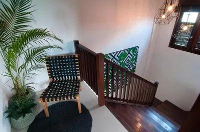 a wooden staircase with a chair and a plant at 3BR Villa Olli - Minggu Villas -Special Stay Bonus in Kerobokan