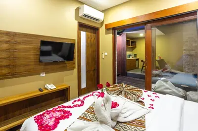 a bedroom with a bed with a tv on the wall at Radea Villa in Kerobokan