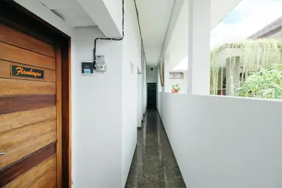 a hallway of a house with a wooden door at D'Tamblingan Guest House at Taman Griya Jimbaran RedPartner - Minimum Stay 30 Nights in Jimbaran