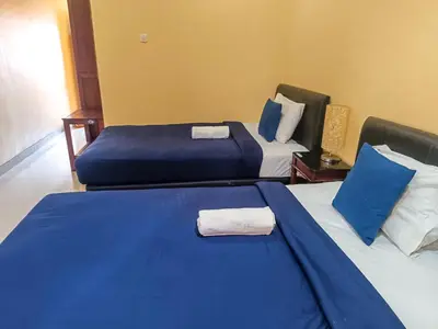a hotel room with two beds with blue sheets at Kuta Paradise 777 in Legian