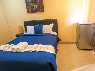 a bedroom with a blue bed with towels on it at Kuta Paradise 777 in Legian