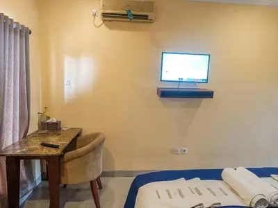 a room with a bed and a tv on the wall at Kuta Paradise 777 in Legian