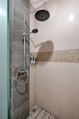 a shower with a shower head in a bathroom at D Sarian Seminyak in Seminyak