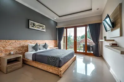 a bedroom with a bed and a large window at D Sarian Seminyak in Seminyak