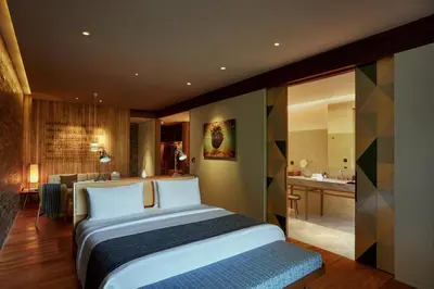 a bedroom with a large bed and a bathroom at Desa Potato Head Bali in Seminyak