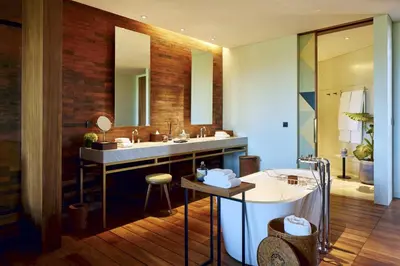 a bathroom with a sink and a tub and a mirror at Desa Potato Head Bali in Seminyak