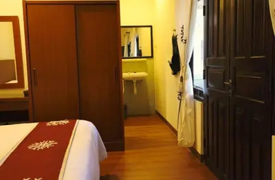 a bedroom with a bed and a bathroom with a sink at Niramaya Villa in Seminyak