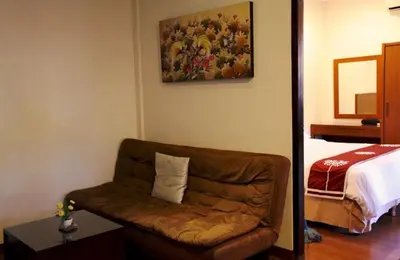 a living room with a couch and a bed at Niramaya Villa in Seminyak