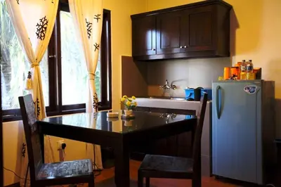 a kitchen with a table and a refrigerator at Niramaya Villa in Seminyak