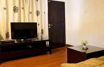 a living room with a flat screen tv and a couch at Niramaya Villa in Seminyak