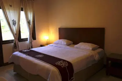 a bedroom with a large bed with white sheets and pillows at Niramaya Villa in Seminyak