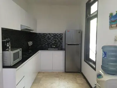 a kitchen with a refrigerator and a microwave at Villa Indah Kuta Royal - Private Pool - Optic Fiber High Speed Internet in Kuta