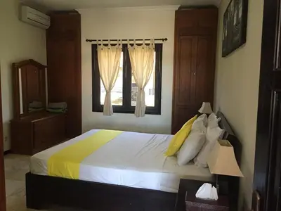 a bedroom with a large bed and a window at Villa Indah Kuta Royal - Private Pool - Optic Fiber High Speed Internet in Kuta